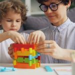 a woman and a child playing with a building set